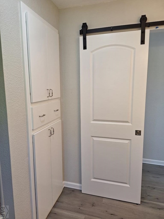 211 W Maplewood, Walsh, CO 81090 - detailed view of a barn door, baseboards, and wood finished floors