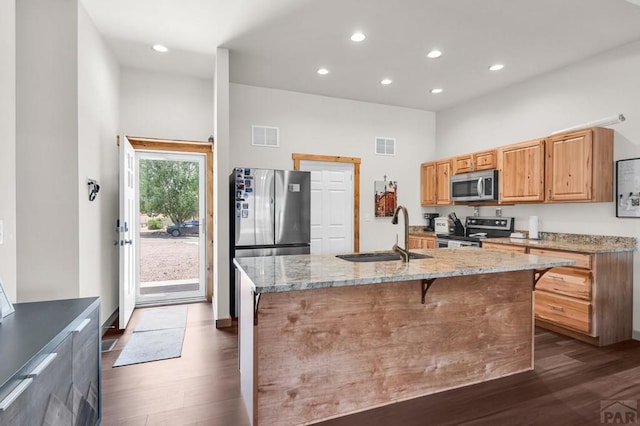 349-351 W Buttercup Way, Pueblo West, CO 81007 - kitchen with appliances with stainless steel finishes, dark wood-style flooring, recessed lighting, light stone countertops, and a center island with sink