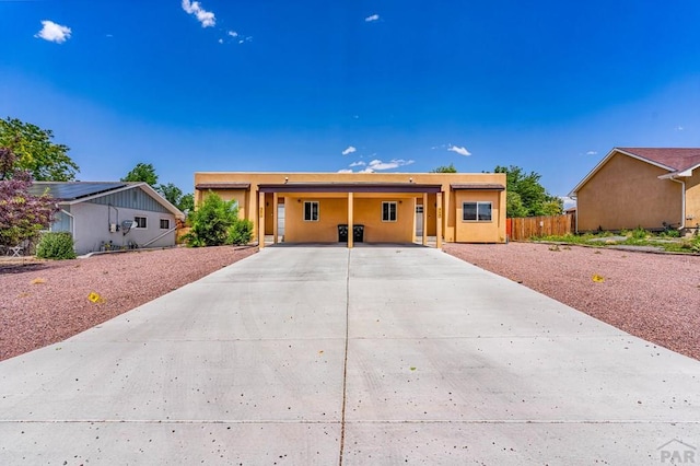 349-351 W Buttercup Way, Pueblo West, CO 81007 - view of front of home with driveway, a carport, and stucco siding