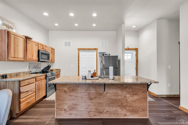 349-351 W Buttercup Way, Pueblo West, CO 81007 - kitchen with stainless steel appliances, dark wood-style floors, recessed lighting, light stone countertops, and a kitchen island with sink