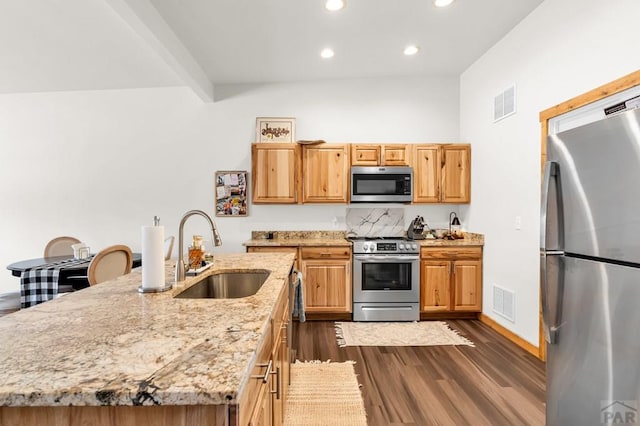 349-351 W Buttercup Way, Pueblo West, CO 81007 - kitchen featuring stainless steel appliances, recessed lighting, dark wood finished floors, light stone countertops, and a center island with sink