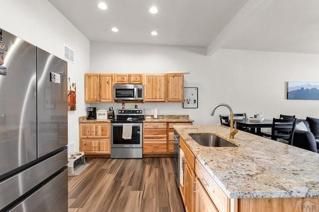 349-351 W Buttercup Way, Pueblo West, CO 81007 - kitchen with stainless steel appliances, dark wood finished floors, light stone countertops, recessed lighting, and a kitchen island with sink