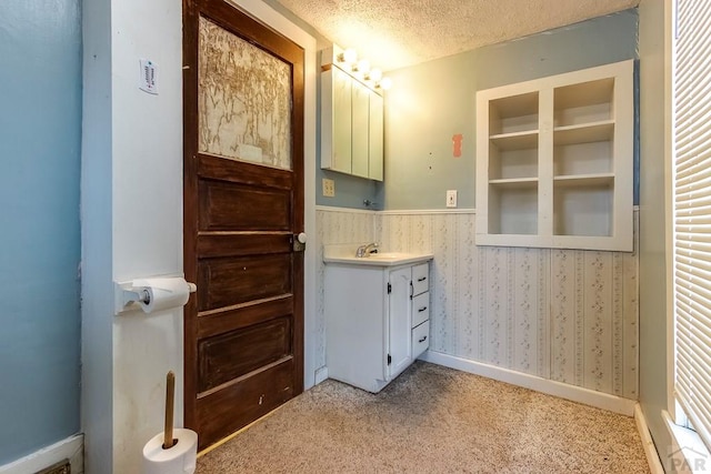 1708 Alta St, Trinidad, CO 81082 - bathroom with vanity, a textured ceiling, and a wainscoted wall