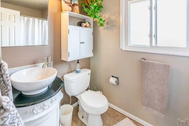 full bathroom with baseboards, vanity, toilet, and tile patterned floors