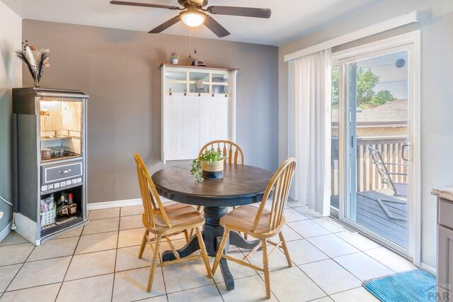 dining room with ceiling fan, light tile patterned flooring, and baseboards