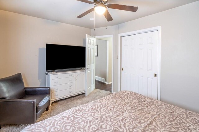 bedroom featuring light colored carpet, a closet, visible vents, and ceiling fan