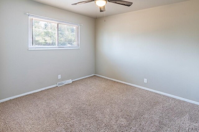 spare room with baseboards, carpet flooring, visible vents, and a ceiling fan