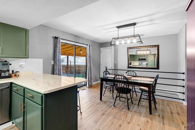 dining area featuring light wood-style floors and baseboards