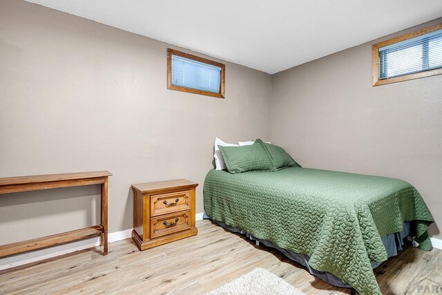 bedroom with baseboards and wood finished floors