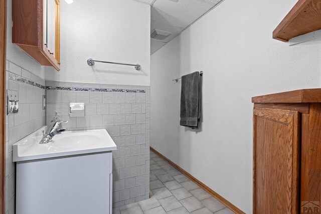 bathroom featuring tile walls and vanity