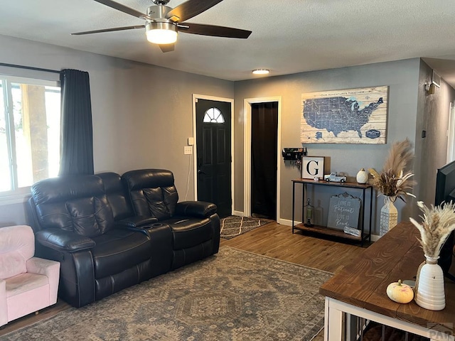 living room featuring a textured ceiling, a ceiling fan, and wood finished floors