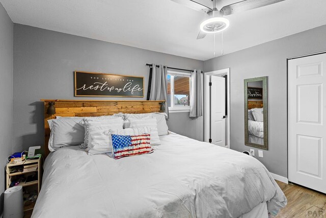 bedroom featuring light wood-type flooring, ceiling fan, and baseboards