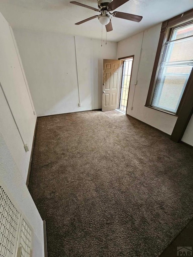 unfurnished bedroom with carpet floors, multiple windows, and a ceiling fan