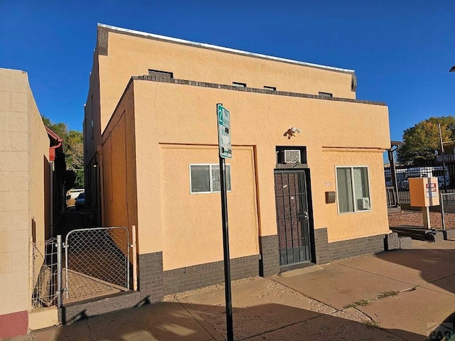 exterior space featuring a gate, fence, and stucco siding