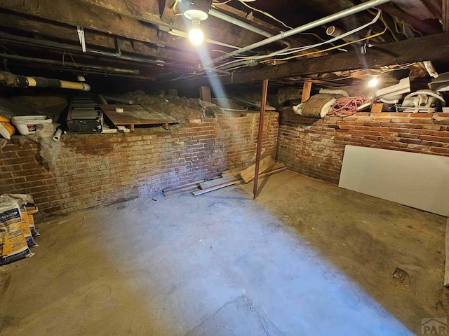 unfinished below grade area with brick wall