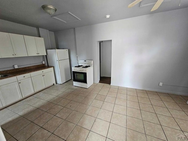 kitchen with light tile patterned flooring, white appliances, a ceiling fan, white cabinets, and dark countertops