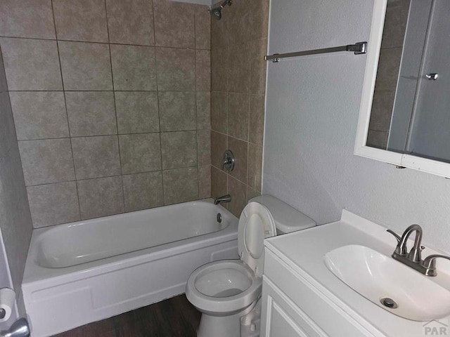 full bathroom with a textured wall, shower / bathing tub combination, toilet, and wood finished floors