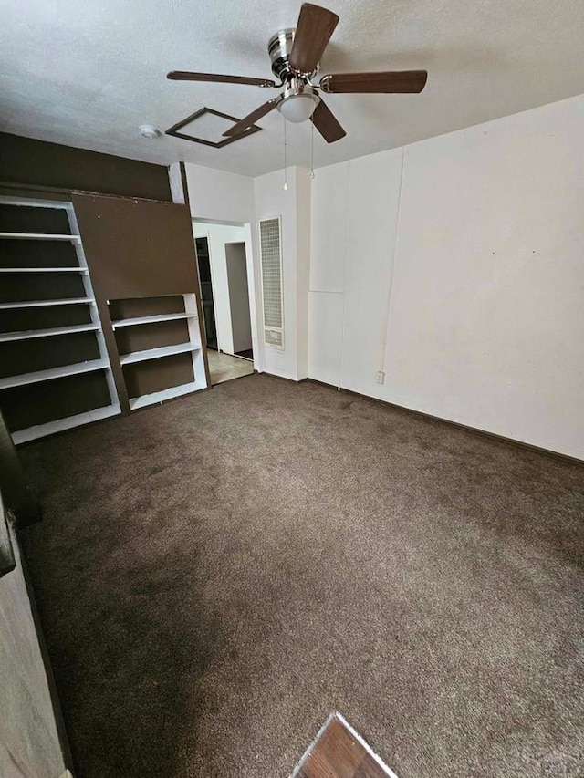 empty room featuring a textured ceiling, carpet floors, and a ceiling fan