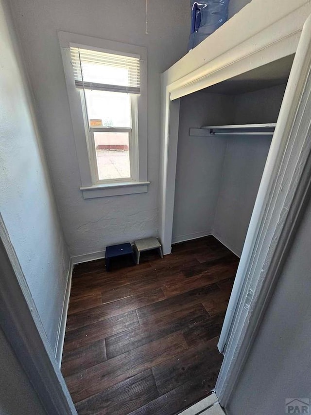 unfurnished bedroom featuring a closet and dark wood finished floors