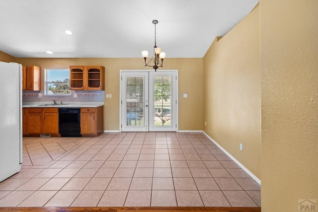 kitchen with black dishwasher, pendant lighting, light countertops, freestanding refrigerator, and light tile patterned flooring