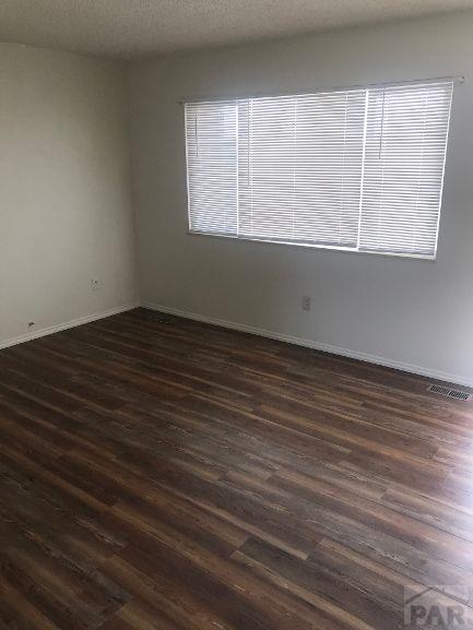 629 E Clarion Dr, Pueblo, CO 81007 - spare room with dark wood-type flooring