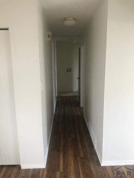 629 E Clarion Dr, Pueblo, CO 81007 - corridor with dark wood finished floors and baseboards