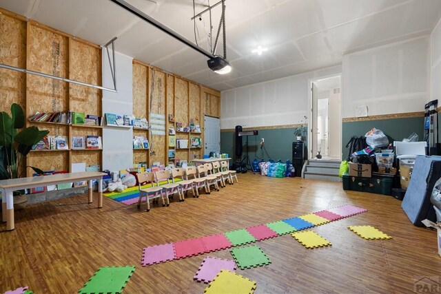 recreation room with a garage and wood finished floors