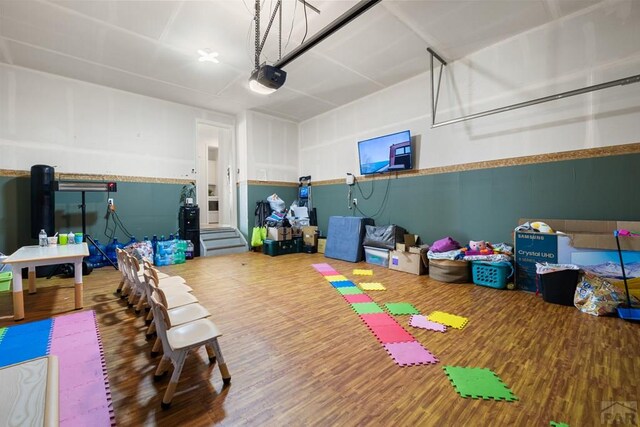 rec room with a garage and wood finished floors