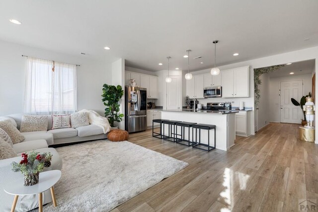 living area with recessed lighting and light wood finished floors