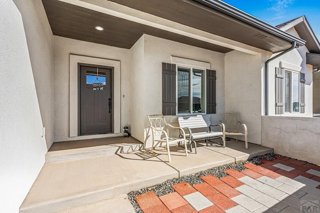 property entrance featuring a porch and stucco siding