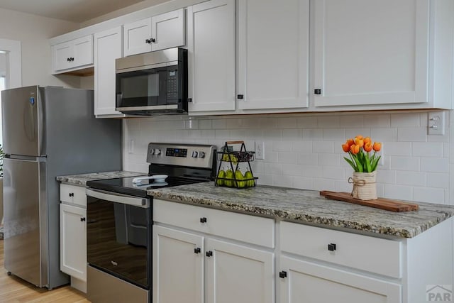 1709 Henry Ave, Pueblo, CO 81005 - kitchen featuring appliances with stainless steel finishes, white cabinetry, light stone countertops, and tasteful backsplash