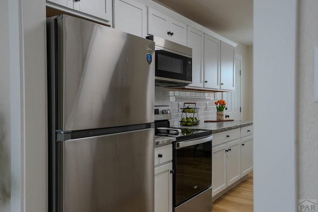 1709 Henry Ave, Pueblo, CO 81005 - kitchen with stainless steel appliances, tasteful backsplash, light stone countertops, and white cabinets