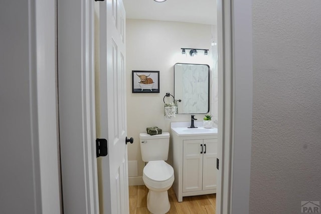 1709 Henry Ave, Pueblo, CO 81005 - bathroom with vanity, wood finished floors, toilet, and a textured wall