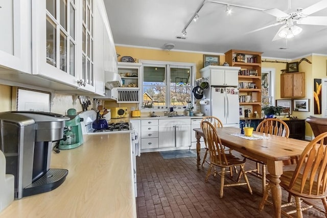 134 E Virginia St, La Veta, CO 81055 - kitchen featuring open shelves, white appliances, brick floors, white cabinetry, and light countertops