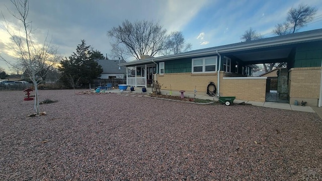 view of front of home featuring fence and brick siding