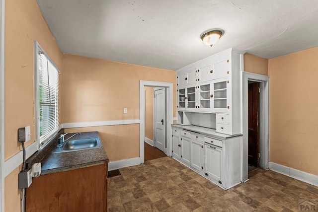 832 Berkley Ave Unit 834, Pueblo, CO 81004 - kitchen featuring white cabinets, stone finish flooring, and glass insert cabinets