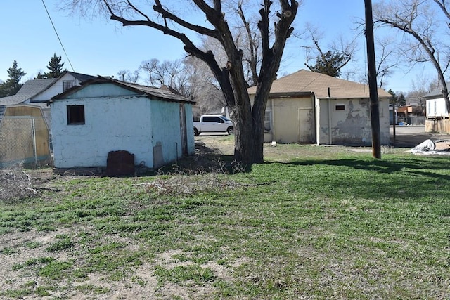 view of yard featuring an outbuilding and fence