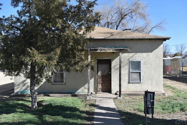 view of front facade featuring stucco siding and a front lawn