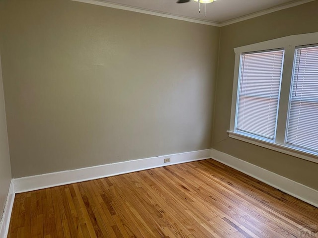 unfurnished room with a ceiling fan, crown molding, light wood-style flooring, and baseboards