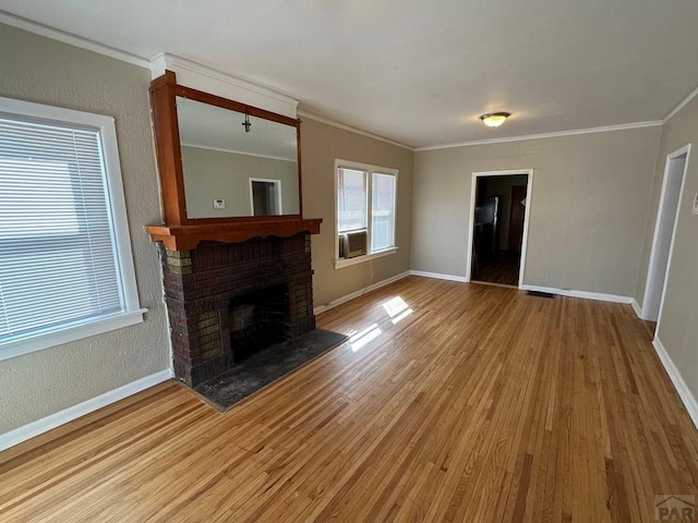 unfurnished living room with a fireplace, baseboards, wood finished floors, and ornamental molding