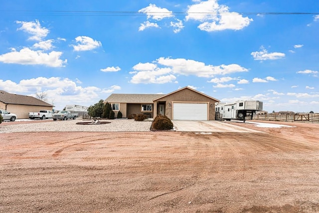 view of front facade featuring a garage, concrete driveway, and stucco siding