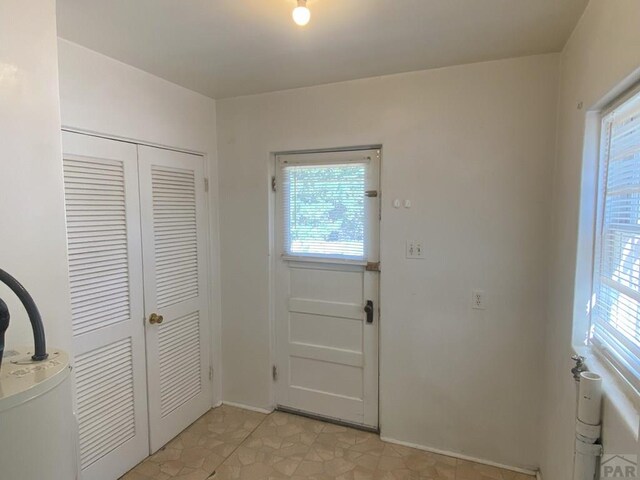 doorway to outside with plenty of natural light and baseboards