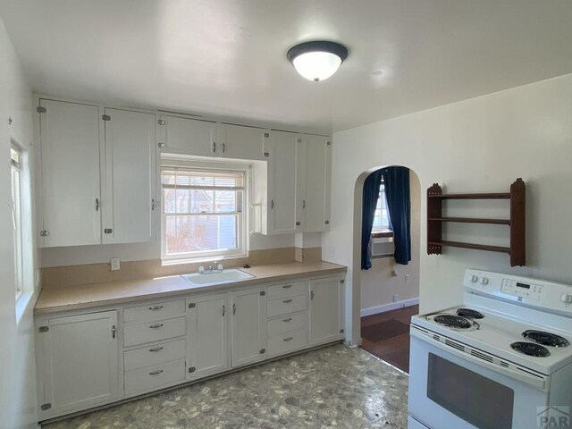 kitchen with light countertops, white electric range, and white cabinetry