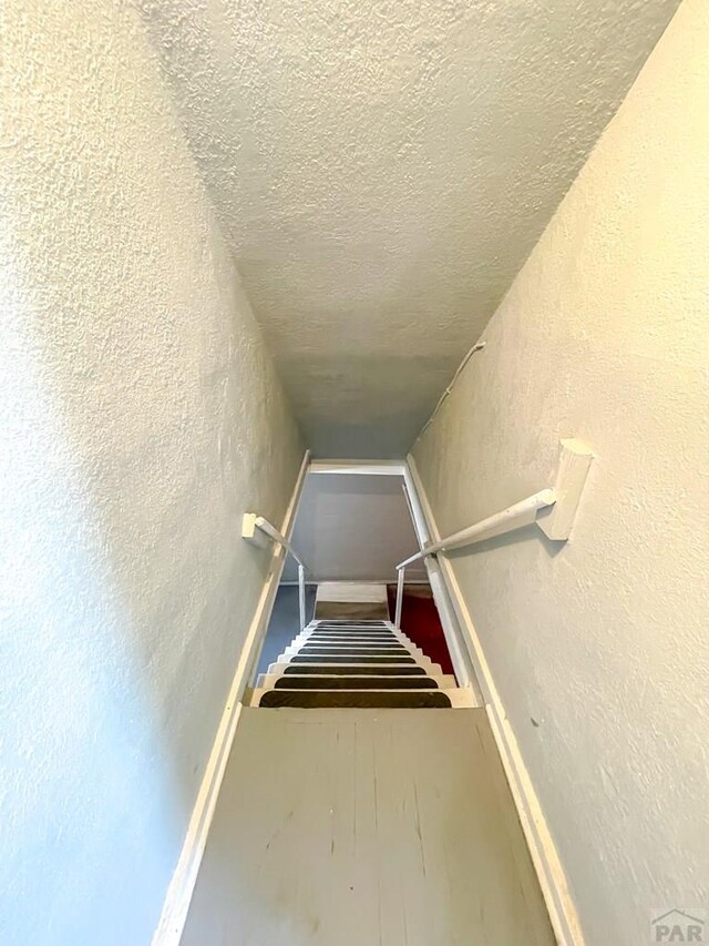 15 E 8th St, La Junta, CO 81050 - staircase with a textured wall and a textured ceiling