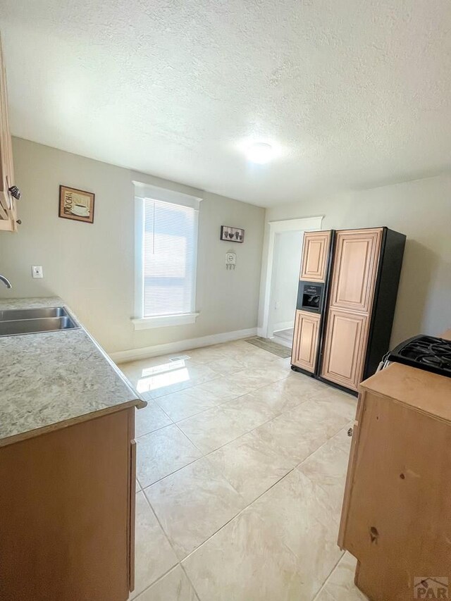 15 E 8th St, La Junta, CO 81050 - kitchen featuring a textured ceiling, light countertops, and light tile patterned flooring