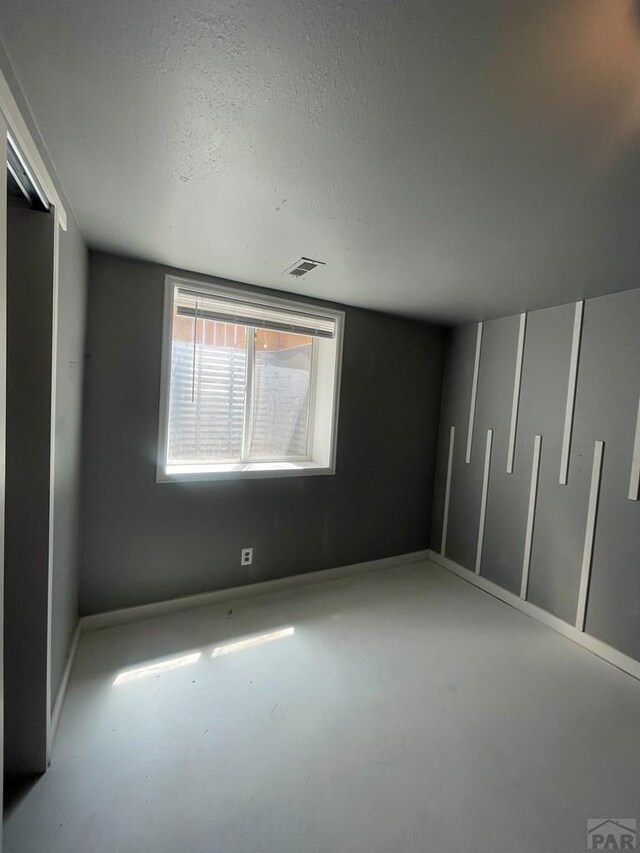 15 E 8th St, La Junta, CO 81050 - unfurnished bedroom featuring a textured ceiling and concrete floors