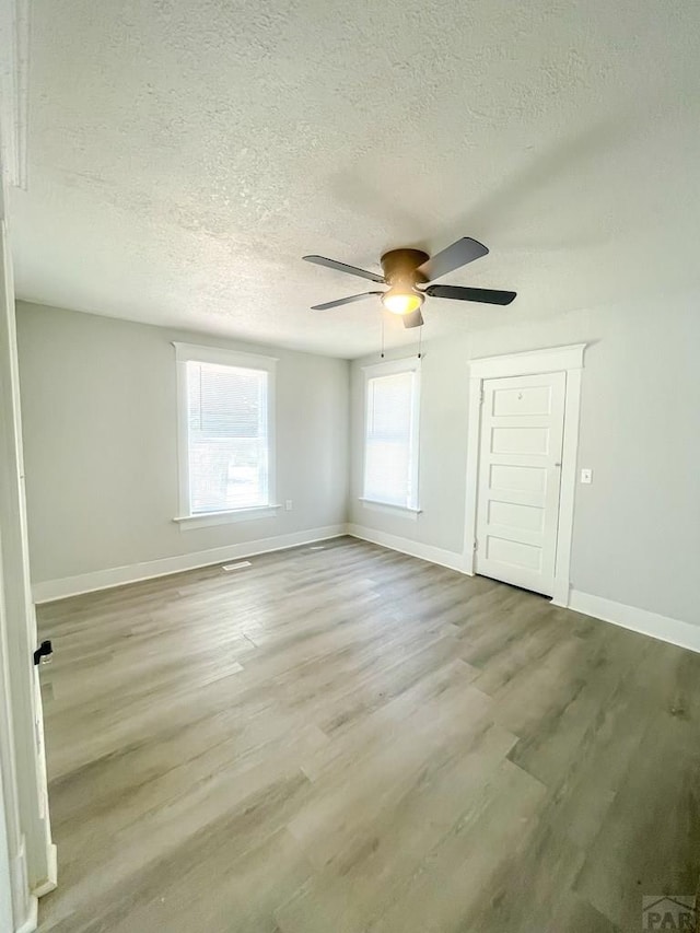 15 E 8th St, La Junta, CO 81050 - spare room featuring a textured ceiling, wood finished floors, and a ceiling fan