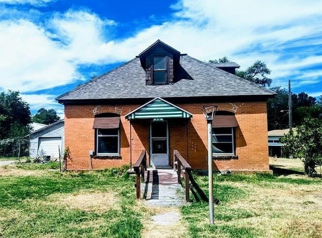 bungalow featuring entry steps, brick siding, and a front lawn