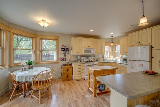 314 S Main St, La Veta, CO 81055 - kitchen with white appliances, baseboards, hanging light fixtures, light countertops, and light wood-type flooring