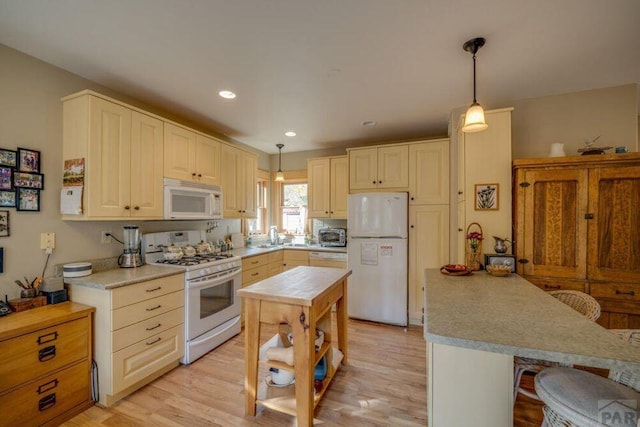 314 S Main St, La Veta, CO 81055 - kitchen with recessed lighting, light countertops, hanging light fixtures, light wood-style floors, and white appliances